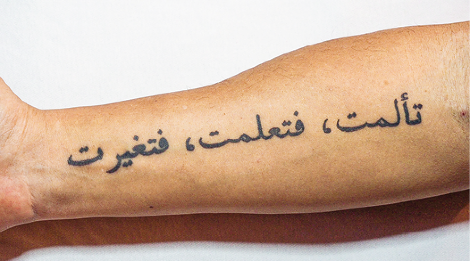 Foto (kleur) arm met Arabische tattoo: ik heb geleden, ik heb geleerd, ik ben veranderd
